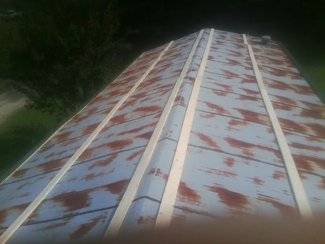 Rusted metal roof panels with new wood purlins before replacement — Storm Damage Roof Repair in Shortsville by Roofing Brothers