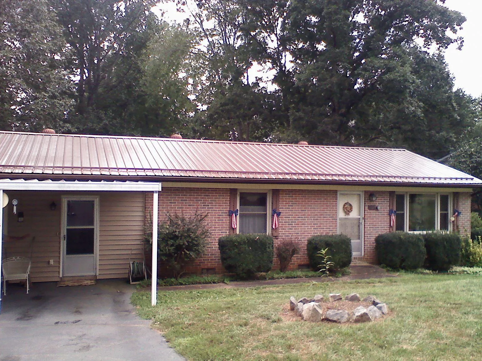 Bronze metal roof and carport on a brick ranch home — Roof Repair work by our crew in Shortsville